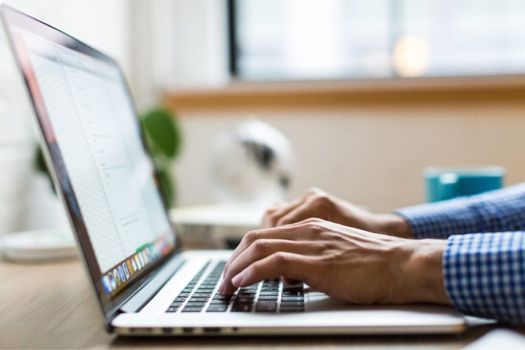 person writing on laptop
